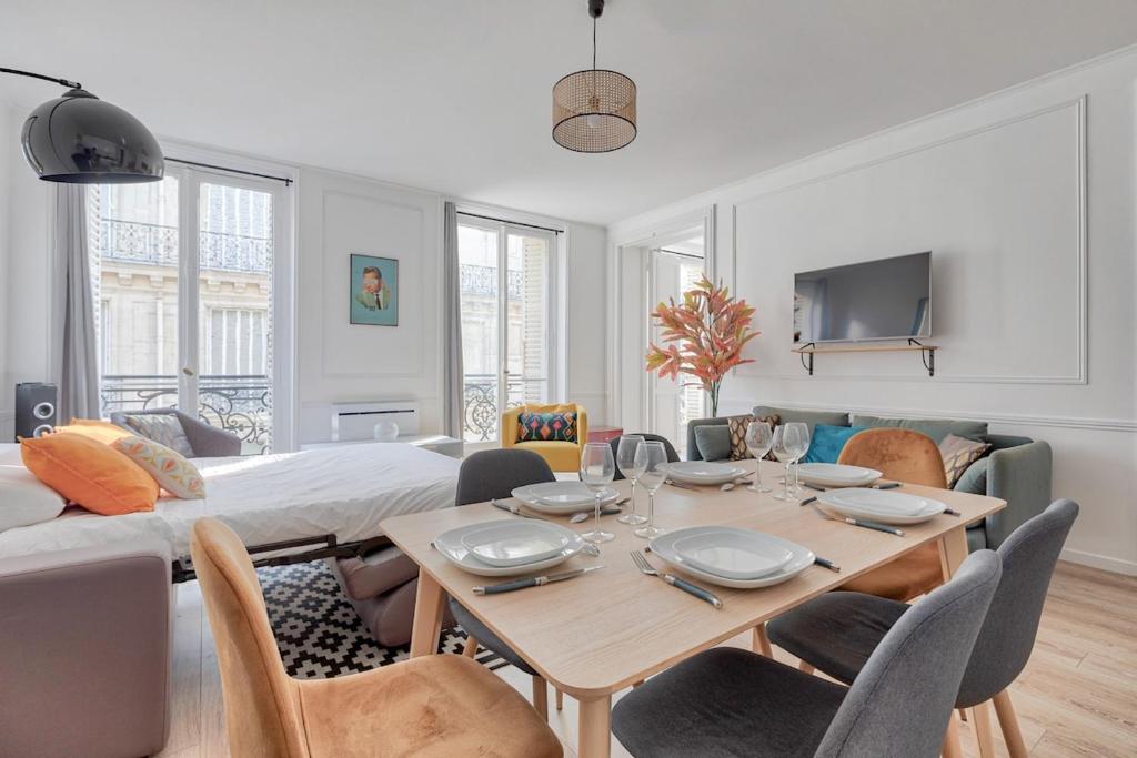 une salle à manger avec une table, des chaises et un canapé dans l'établissement Joli appartement Champs Elysées - 6P, à Paris