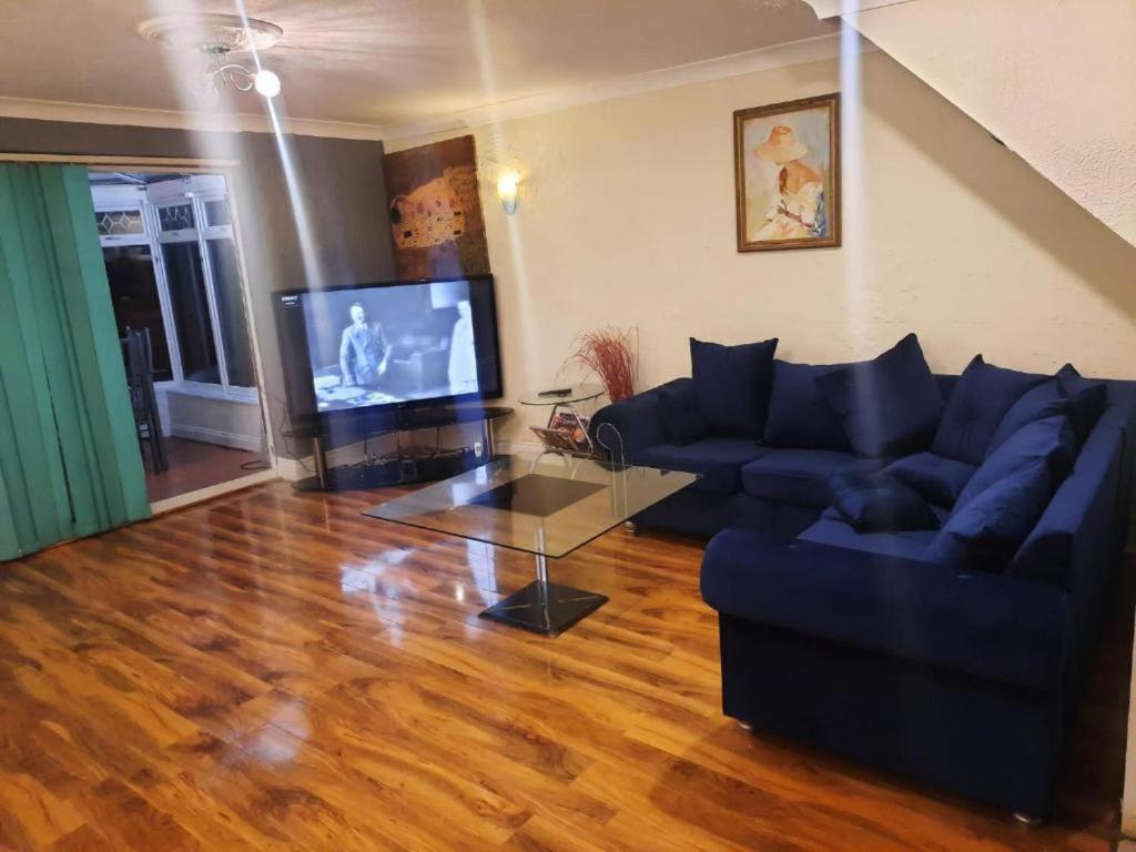ein Wohnzimmer mit einem Sofa und einem TV in der Unterkunft Beautiful 3-Bed House in London in London