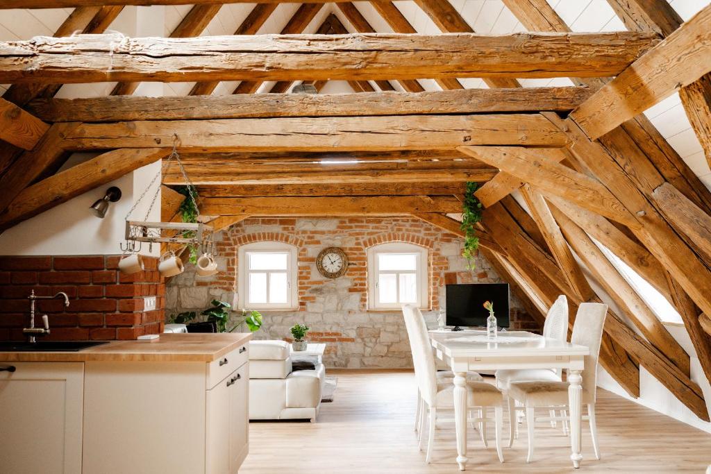 a kitchen and living room with wooden ceilings and a table and chairs at Der Moserhof in Oberaurach