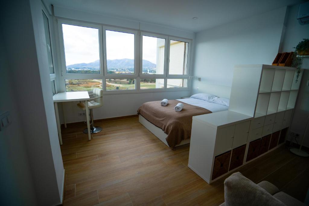 Sunstay Seaview Guadalmar في مالقة: غرفة نوم صغيرة بها سرير ونافذة