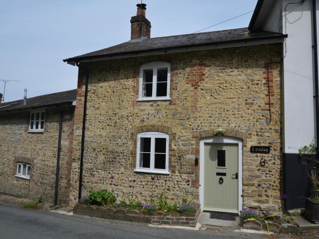 una vecchia casa di mattoni con una porta bianca di 2 Bed in Dorchester 66192 a Stratton