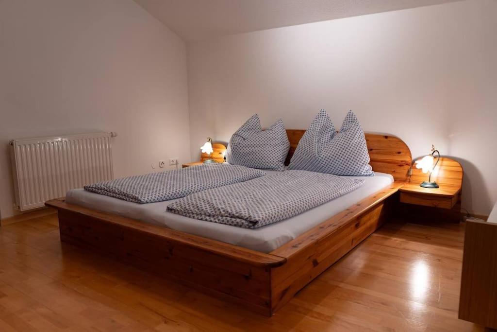 Un dormitorio con una gran cama de madera con almohadas blancas. en Tanjas gemütliches Haus am Mondsee en Innerschwand