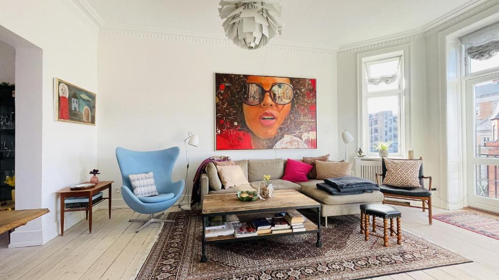 a living room with a couch and a painting on the wall at ApartmentInCopenhagen Apartment 1590 in Copenhagen