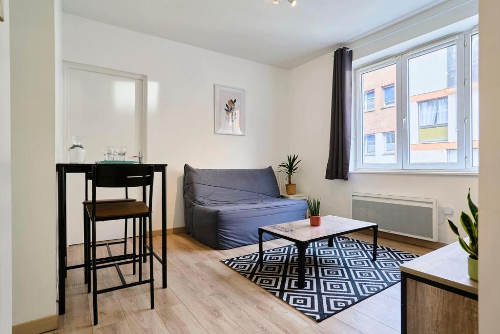 a living room with a couch and a table at Quiet one-bedroom flat close to the metro in Lille