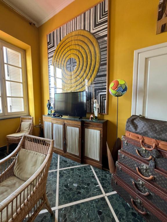 a living room with yellow walls and a tv and chairs at artemare in Viareggio