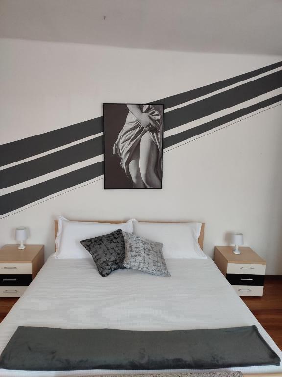 a bedroom with a white bed with black and white stripes at Regina di Cuori in Andorno Micca