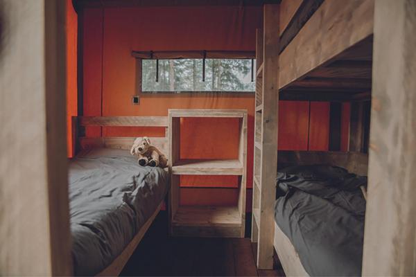 a bedroom with two bunk beds and a dog laying on the bed at Camping Saint-Lambert - Maeva in Millau