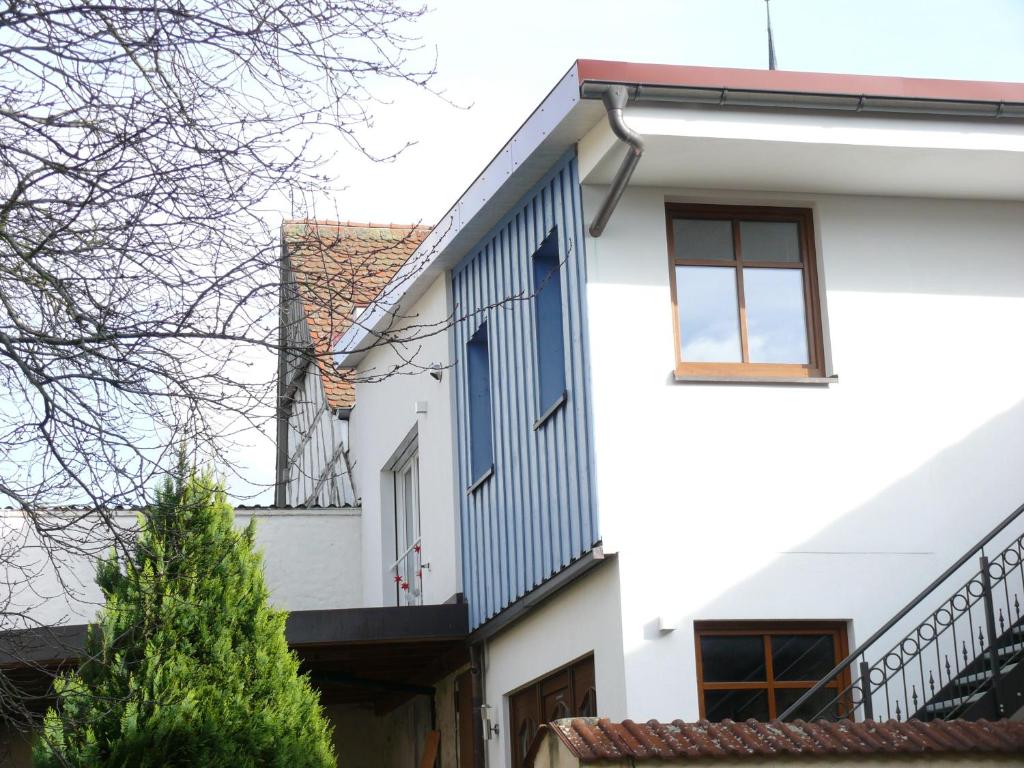 a white house with blue shutters on it at Ferienwohnungen Fischer in Strullendorf