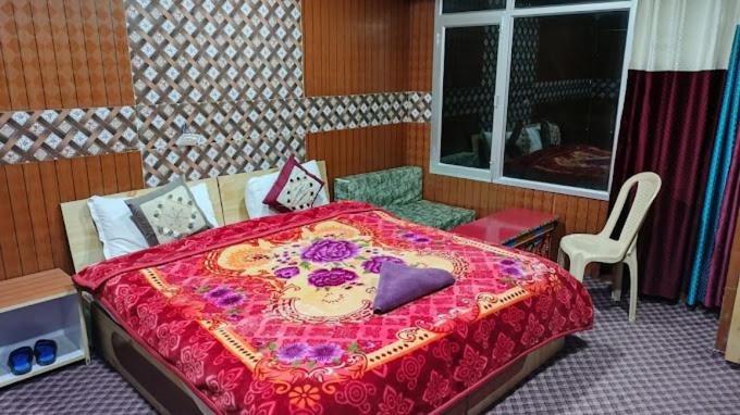 a bedroom with a large bed with a red blanket at Soma Retreat Cottage, Pangong Lake in Kakstet