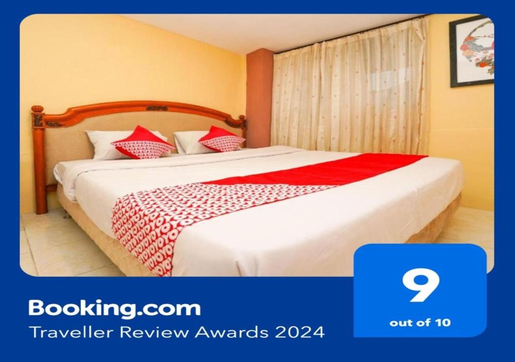 une chambre d'hôtel avec un lit et une couverture rouge dans l'établissement SUPER OYO 710 Naomi Heritage, à Surabaya