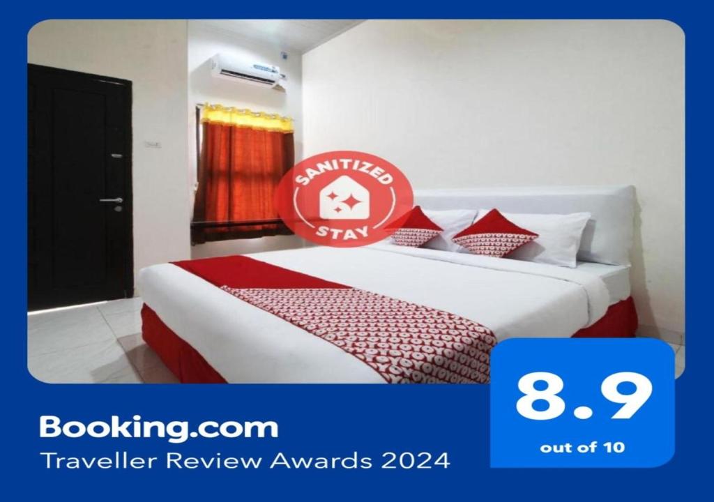 una habitación de hotel con una cama con un cartel. en Super OYO 1678 Jati Exclusive Homestay en Bengkulu