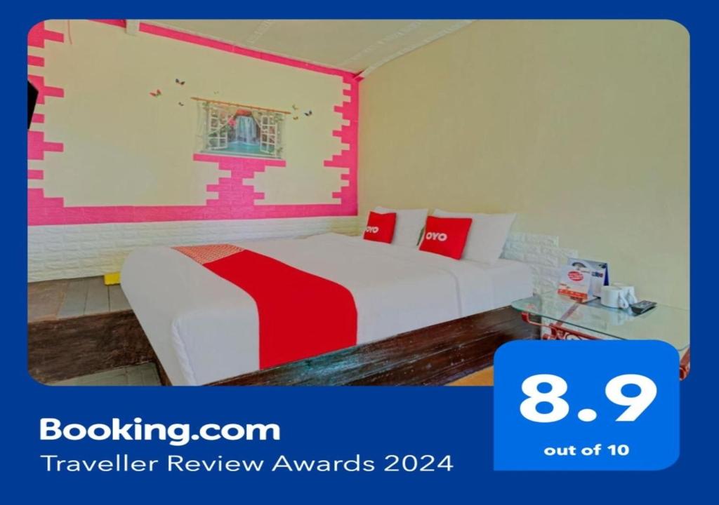 a bedroom with a bed with a red and white blanket at Super OYO 3208 Villa Inn App Trawas Bintaro Syariah in Kemloko-gede