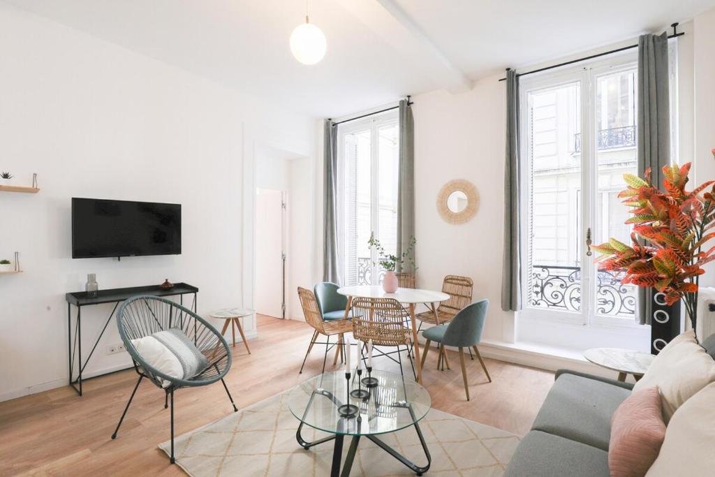 een woonkamer met een tafel en stoelen bij Splendide appartement proche Opéra Garnier - 6P in Parijs