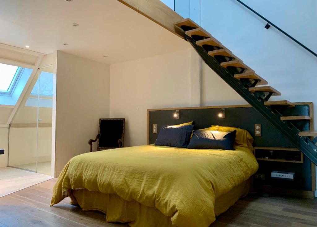 a bedroom with a large bed and a staircase at Suite dans villa moderne avec piscine in Arradon