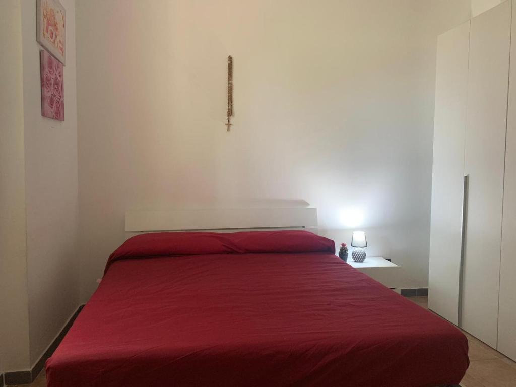 una camera con un letto con una coperta rossa di CASA VACANZA GALLIPOLI a Matino