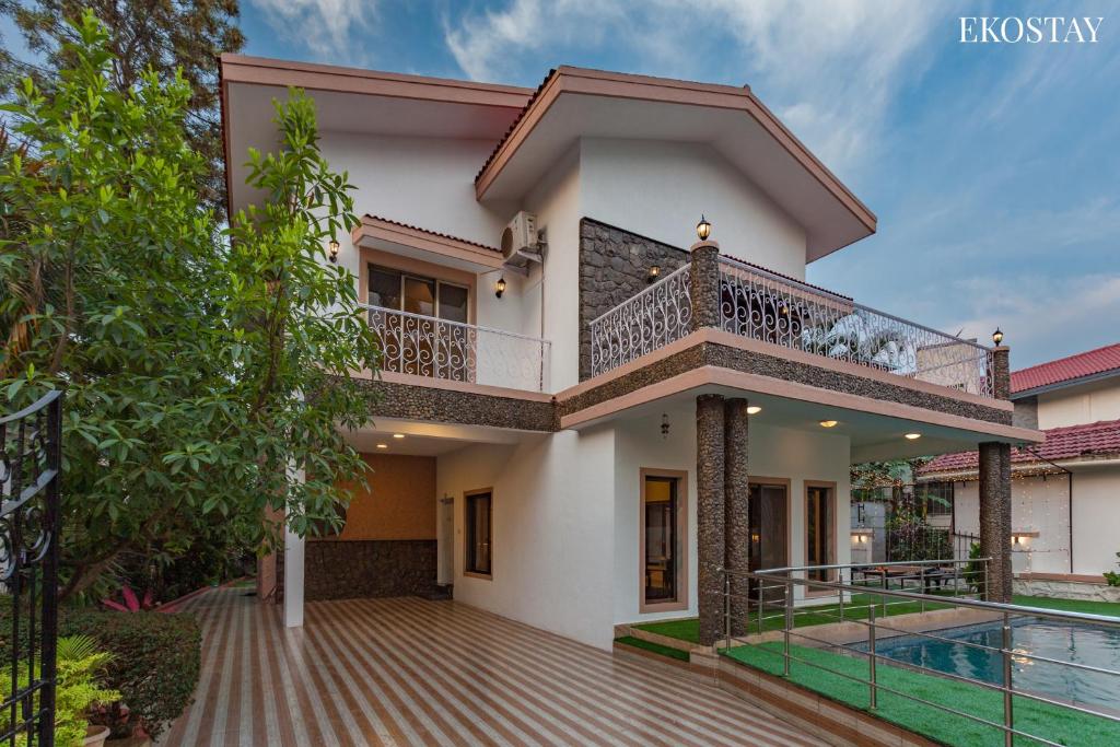 una casa con balcone e piscina di EKO STAY- Paramount Villa a Lonavala