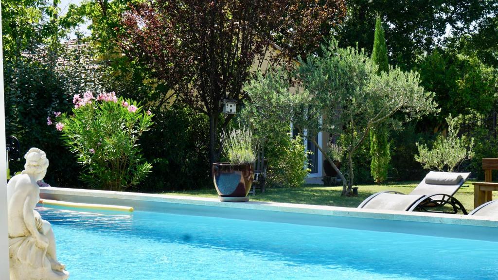 La belle histoire Gîte Montmirail في بيدوان: مسبح بتمثال بجانب ساحة