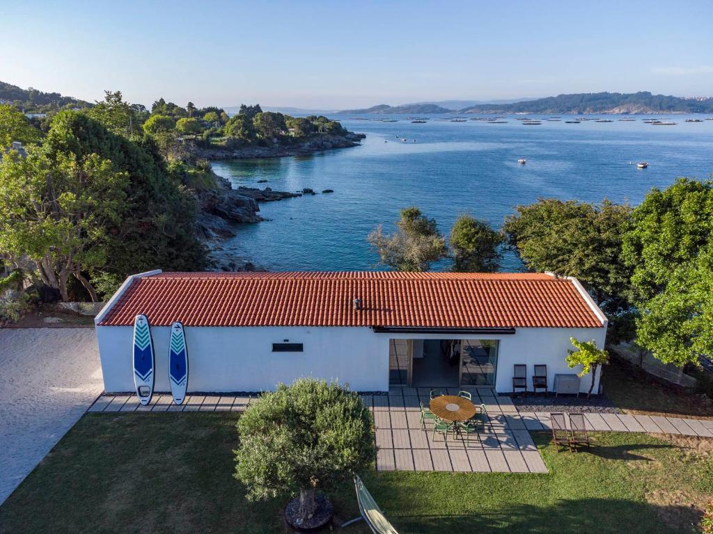 una vista aérea de una casa con vistas al agua en A Factoria Beach House by Prishomes, en Hío