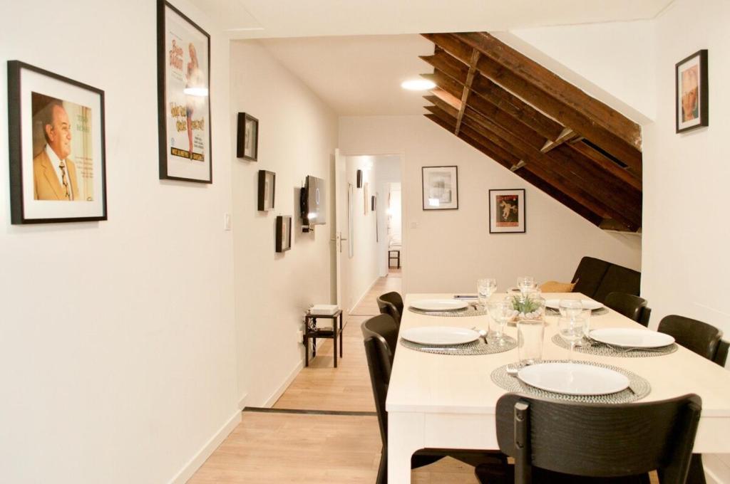 une salle à manger blanche avec une table et des chaises blanches dans l'établissement Bonne Graine : Appartement parisien branché à 10 min de Bastille, à Paris