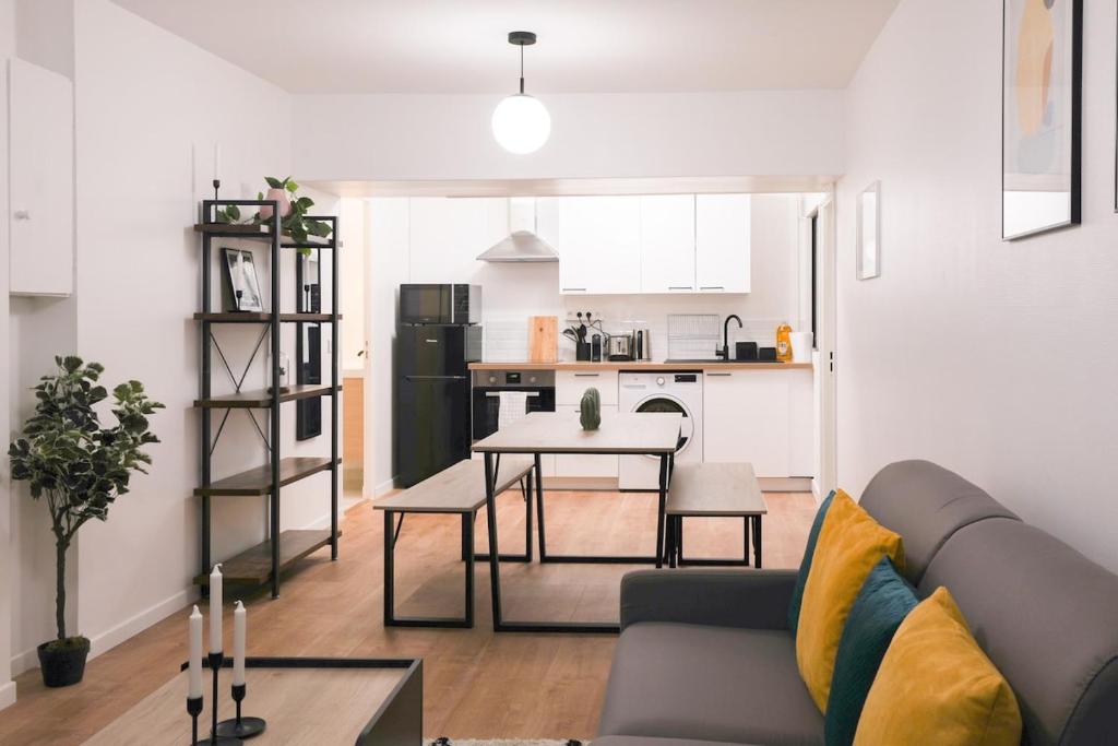 a living room with a couch and a table and a kitchen at Joli appartement Parc de la Villette - 4P in Paris