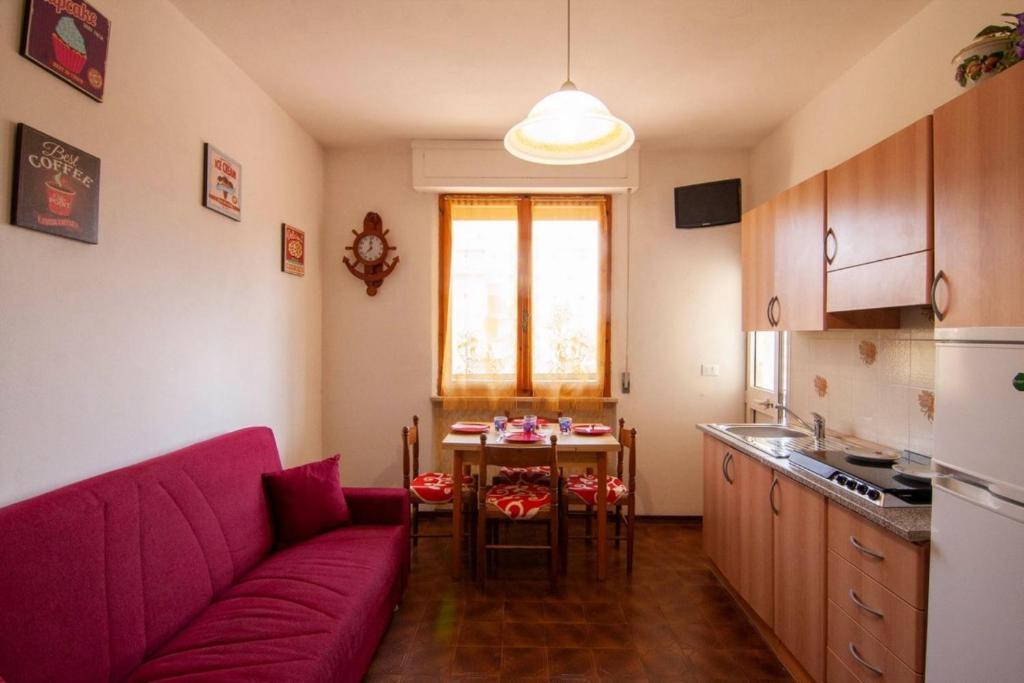 ein Wohnzimmer mit einem lila Sofa und einem Tisch in der Unterkunft Appartamento PE in Follonica