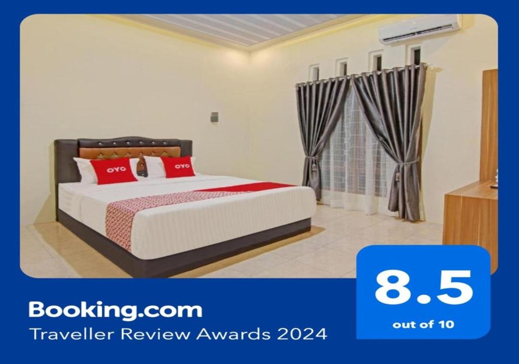 1 dormitorio con 1 cama con almohadas rojas en Super OYO Capital O 90643 Suri Guest House Syariah en Padang