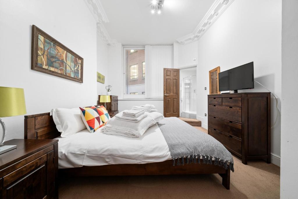 Apartment 1, 48 Bishopsgate by City Living London في لندن: غرفة نوم بسرير كبير وتلفزيون