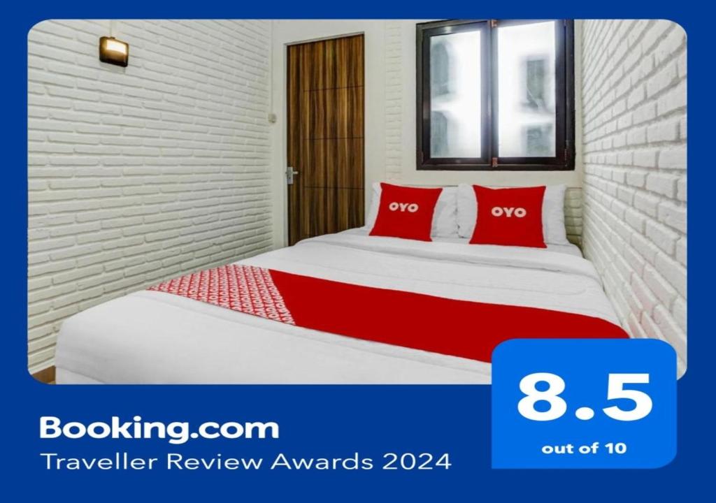 ein Schlafzimmer mit einem Bett mit roten Kissen in der Unterkunft Super OYO 90828 Ara Guest House in Batu