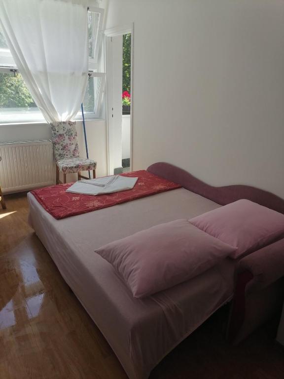 a bed in a room with a window at Flowers Apartment Tuzla in Tuzla