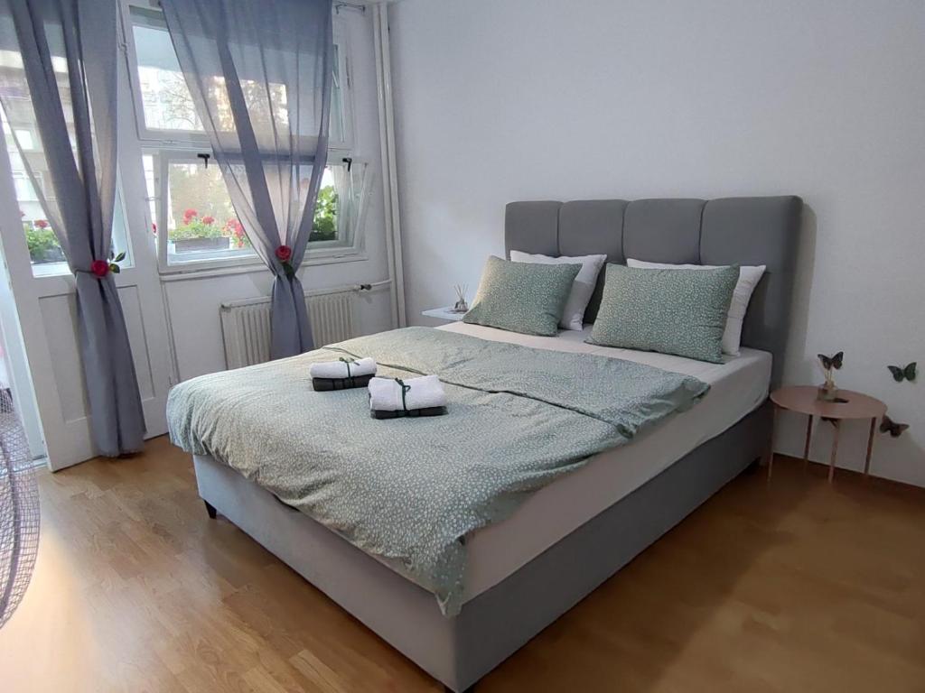 a bedroom with a bed with two towels on it at Flowers Apartment Tuzla in Tuzla