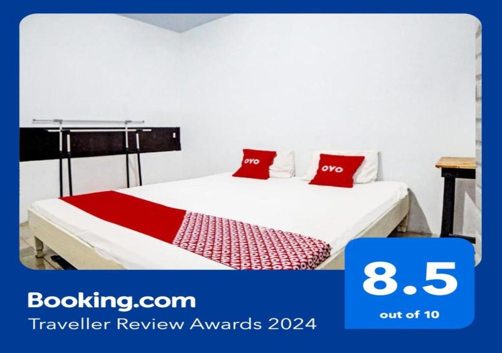 Sunggal的住宿－OYO 91959 La Khansa Homestay Syariah，一间卧室配有一张带红色枕头的床
