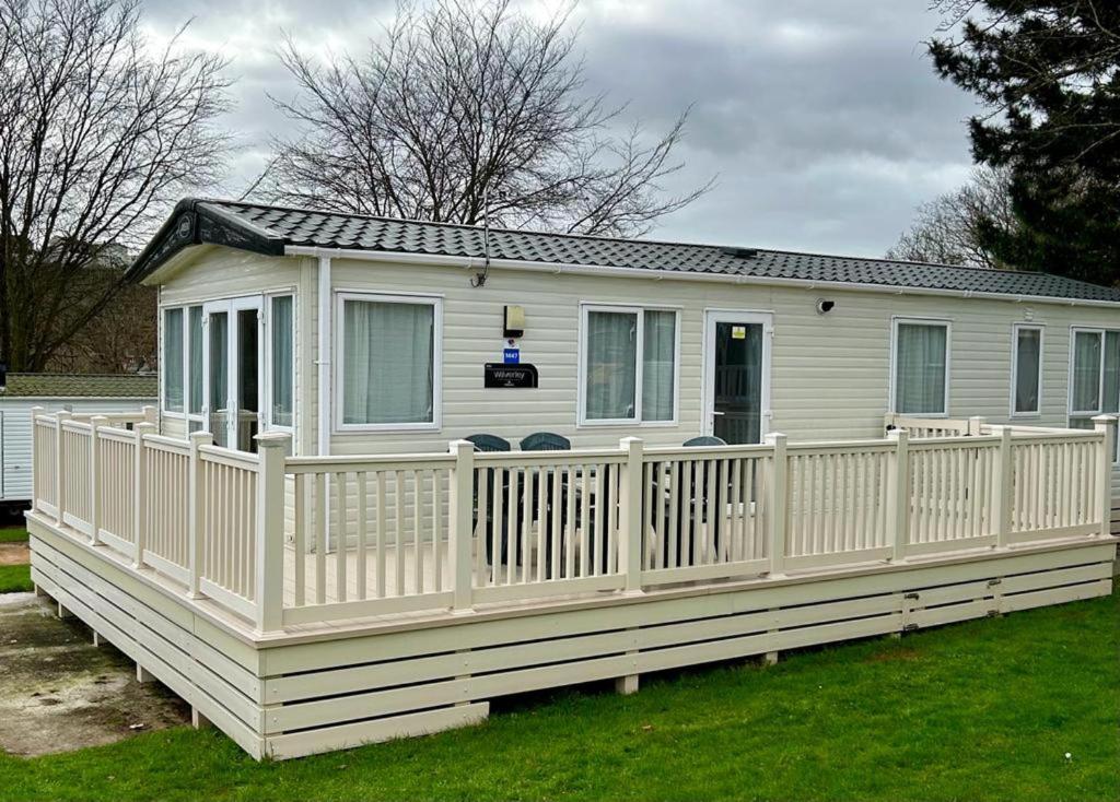 a white mobile home with a white fence at Beautiful Static Caravan Hoburne Devon Bay in Paignton