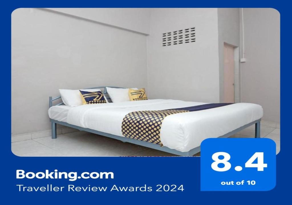 uma cama num quarto branco com aversão a em SUPER OYO 2200 Hotel Gunung Sari em Rantauprapat