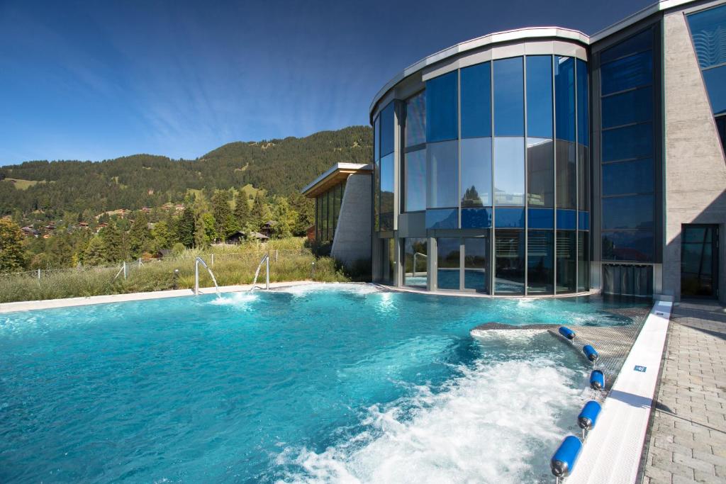 a house with a swimming pool next to a building at Maison des Sports in Villars-sur-Ollon