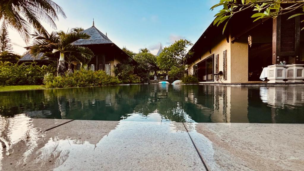une maison avec une piscine d'eau en face d'une maison dans l'établissement Villa Kaz' Grenadine, à Bel Ombre