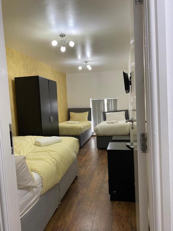 マンチェスターにあるRusholme Roomsのベッド2台とソファが備わる客室です。