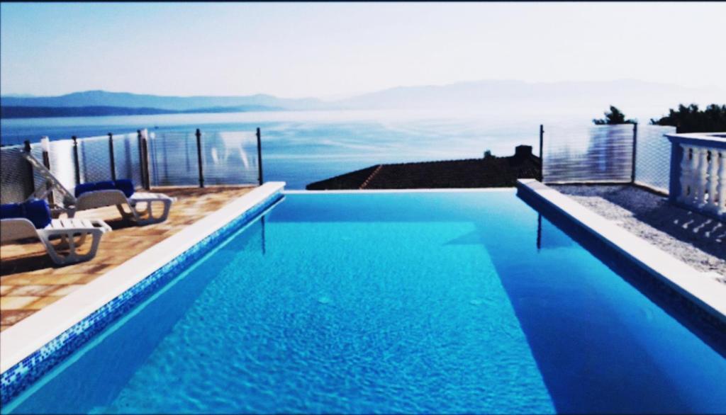 a swimming pool with a view of the water at Villa Sunrise With Sea View in Rogač