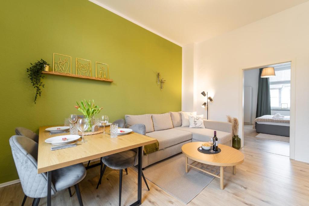 uma sala de estar com uma mesa e um sofá em Stadtwohnung Helene in Messenähe em Essen