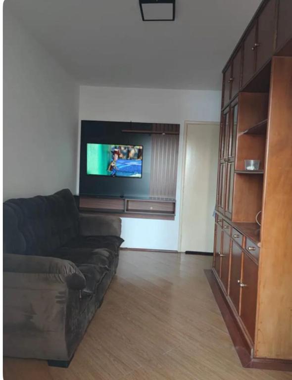 a living room with a couch and a flat screen tv at Apartamento no Centro de Campo Grande in Campo Grande