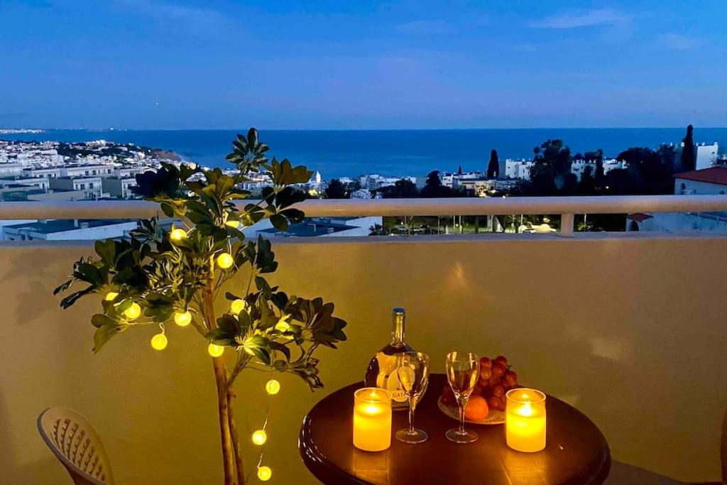 einen Tisch mit Kerzen und Weingläsern auf dem Balkon in der Unterkunft Apartment Vista Mar Piscina Albufeira in Albufeira
