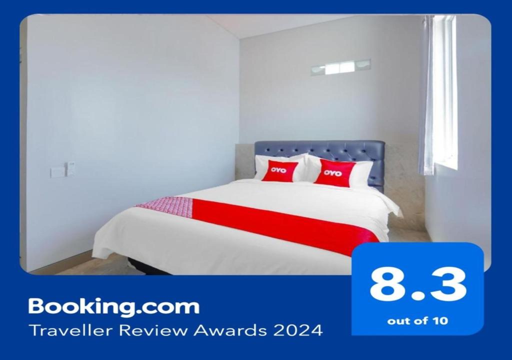 sypialnia z łóżkiem z czerwonymi poduszkami w obiekcie Super OYO Capital O 90336 Olive Guest House w mieście Surabaja