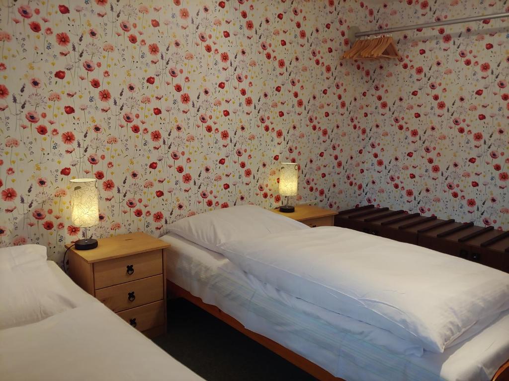 2 camas en un dormitorio con flores en la pared en Ferienwohnung am Garten, en Weißenberg