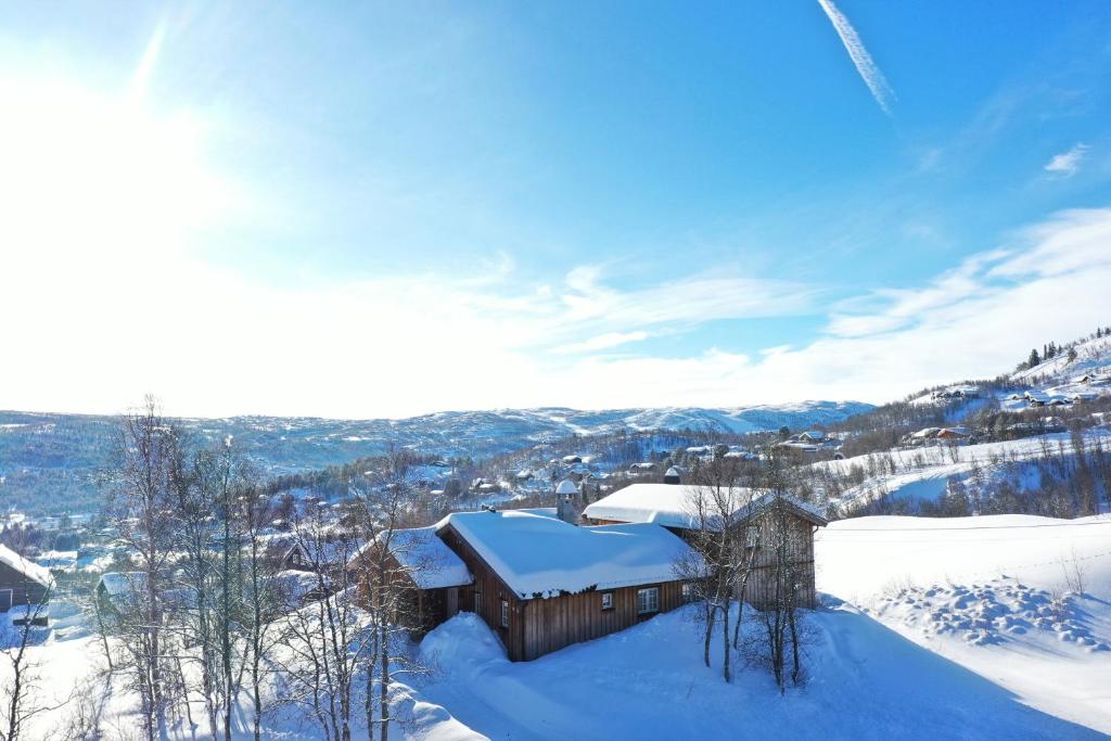 a building covered in snow on top of a mountain at Solrik og flott hytte i Havsdalen in Geilo