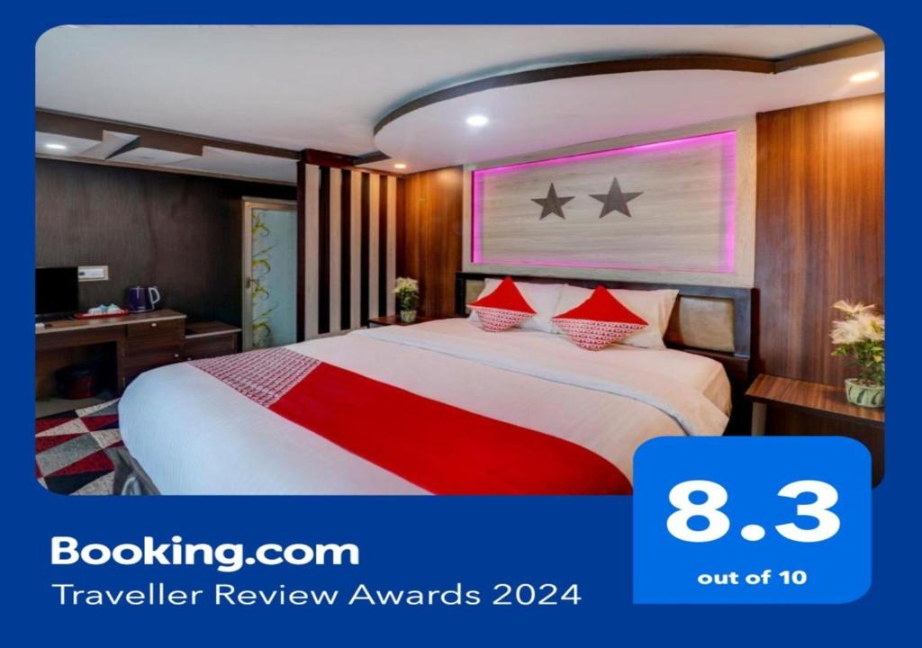Collection O 90564 Hotel Merangin Syariah في Bangko: غرفة فندق بسرير كبير ومخدات حمراء