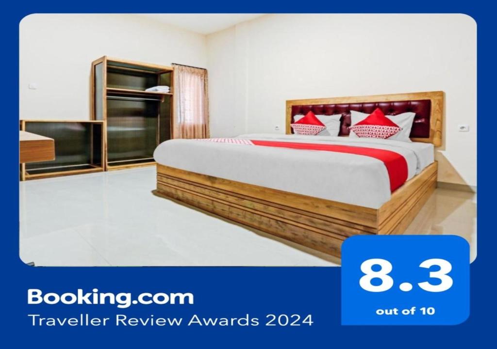 a bedroom with a large bed with red pillows at Capital O 90428 Remington Hotel in Palembang