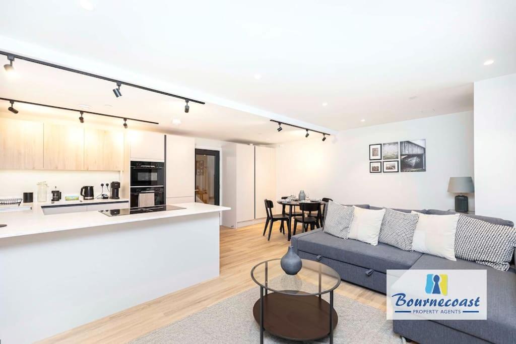 a living room and kitchen with a couch and a table at Bournecoast - Brand New Clifftop Apartment with Balcony - FM9574 in Bournemouth