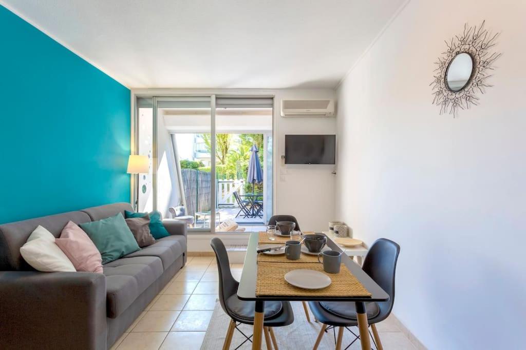 un salon avec un canapé et une table dans l'établissement Chez Alexandra - Élégant studio avec parking à proximité des plages, à La Grande Motte
