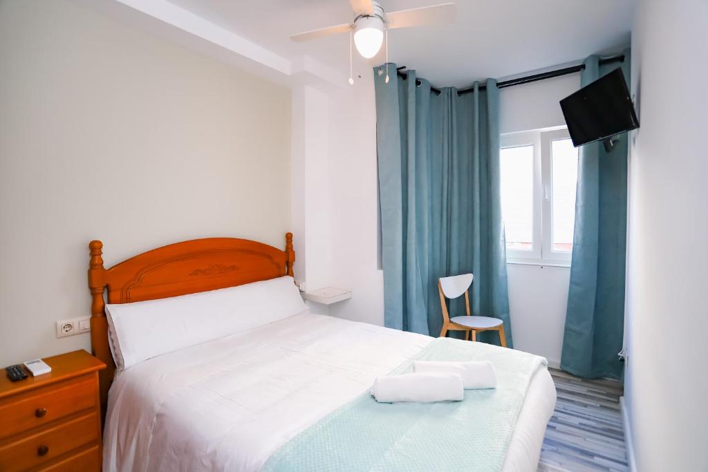 a bedroom with a bed with two towels on it at Pensión Caldas in Caldas de Reis