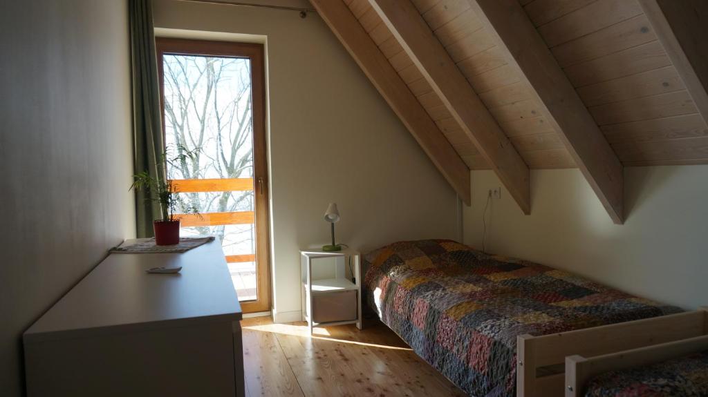 a bedroom with a bed and a large window at Domek w Lasówce in Lasowka