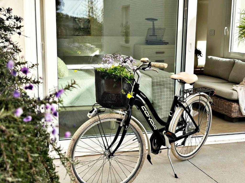 una bicicleta estacionada en un porche con una cesta de flores en Holibai, Vila Panxon, Diseño, Elegancia Y Confort Cerca Del Mar, en Nigrán